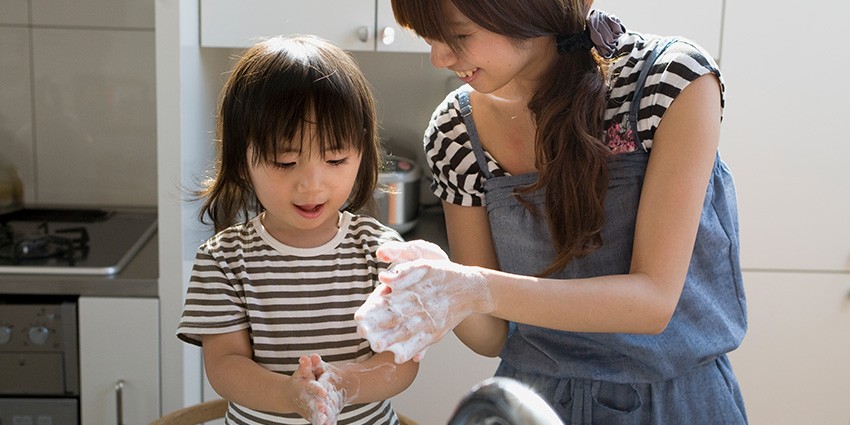 A photo of a mother and daughter washing their hands together