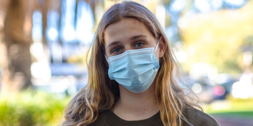 image of a young female person wearing a surgical face mask