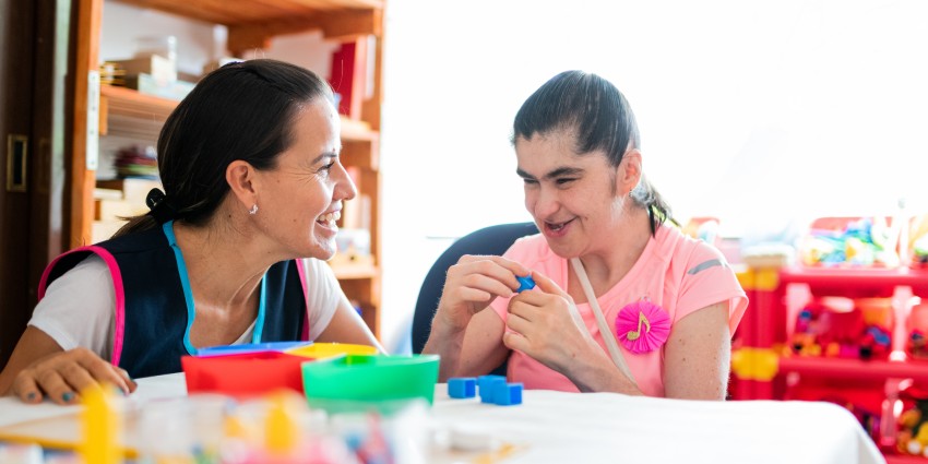 A woman with a disability working with her carer.