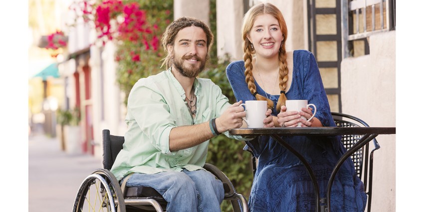 Man in wheelchair at cafe with woman