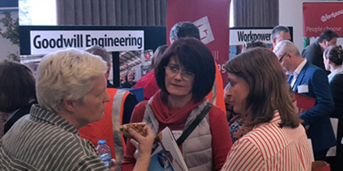 Three ladies having a conversation at a conference.