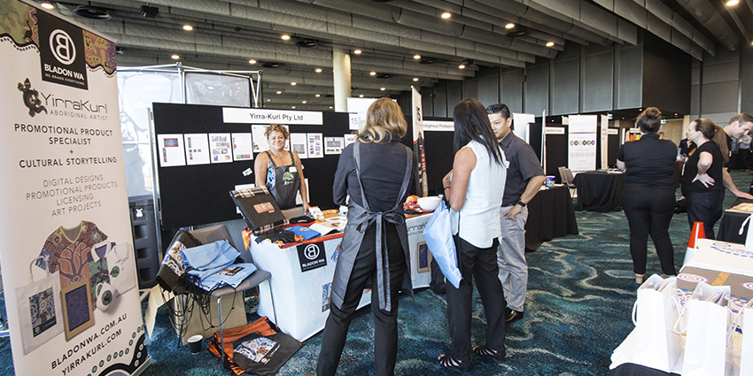 Several people standing around a market stall.