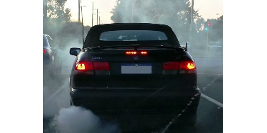 car with smoke coming from exhaust and surrounded in a cloud of smoke