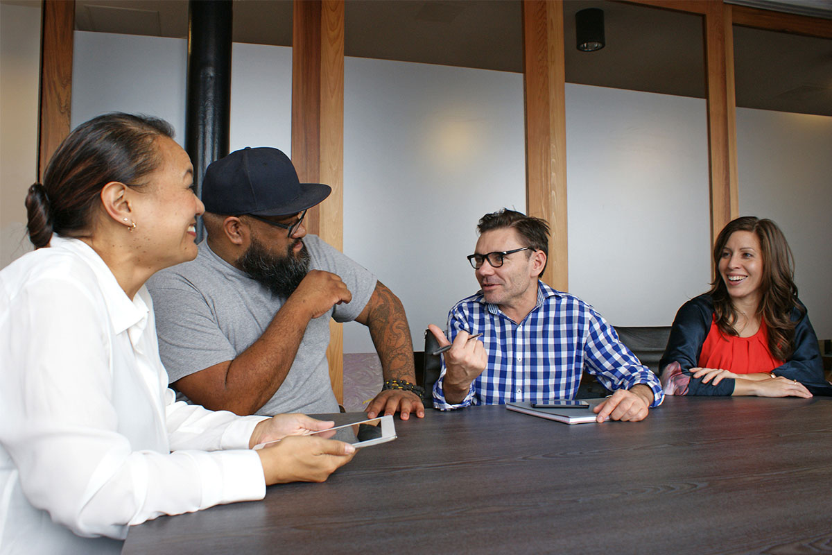 Four happy employees are relaxed in a business meeting.