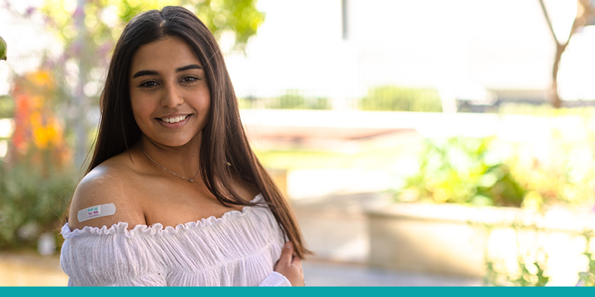 Young person wearing a white top with a roll up for WA bandaid on her arm.