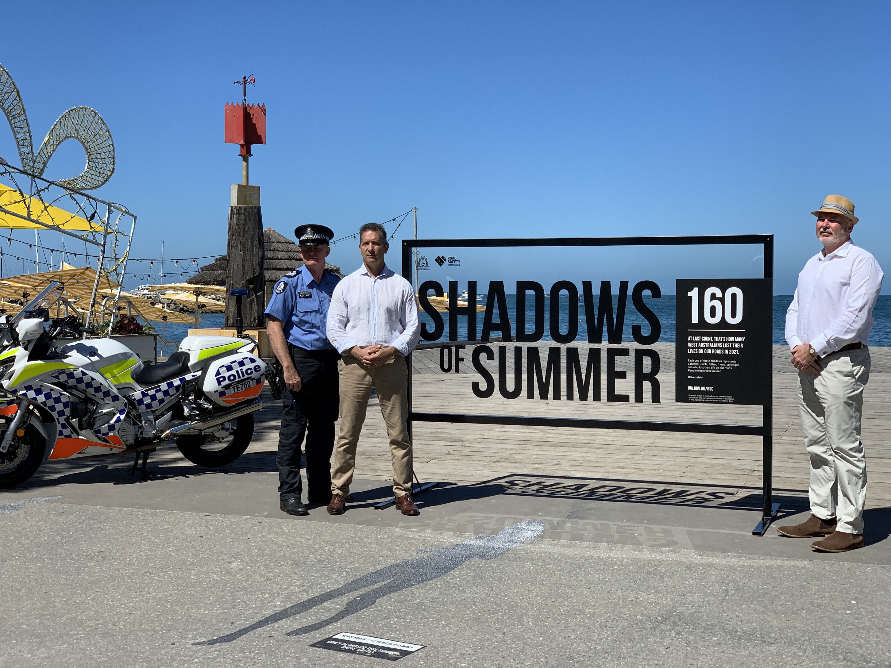 Policeman and minister with shadows of summer campaign sign
