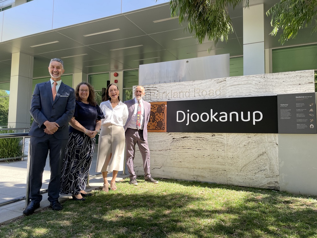 Hon Dr Minister Tony Buti, Director General Nicki Godecke, Director General Karen Ho, and Director Moodjar Consultancy Len Collard stand in front of new building signage that has the word 'Djookanup' written on it.