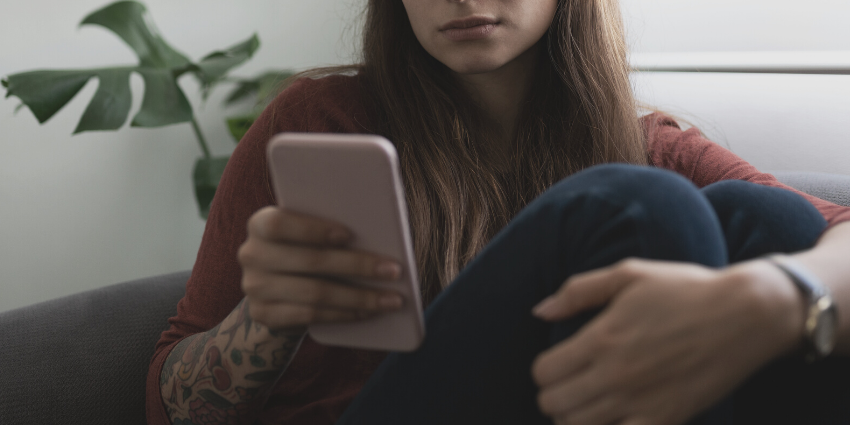 A person with a mobile phone indoors