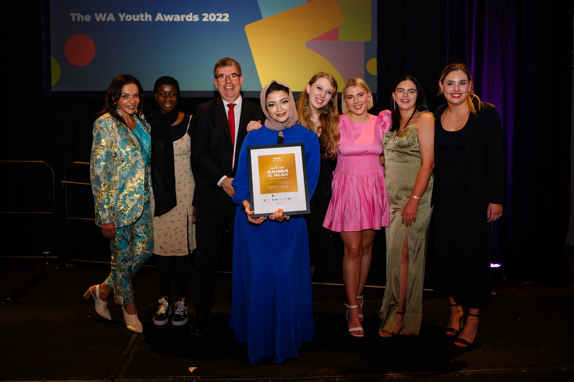 People smiling holding award