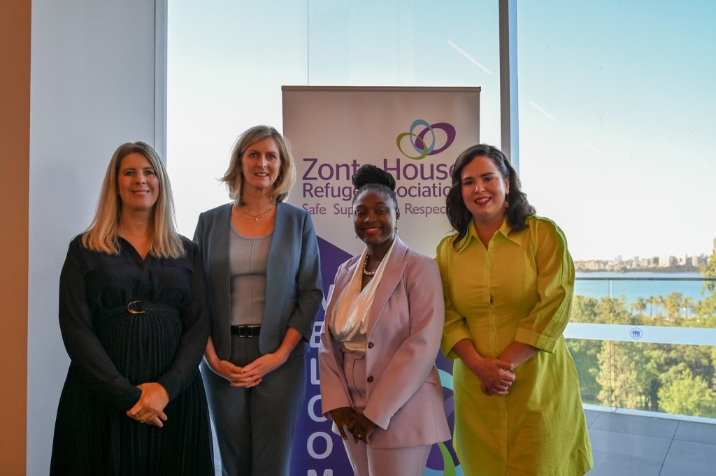 Four female members of Zonta House Refuge Association, standing in front of a Zonta House pull up banner.