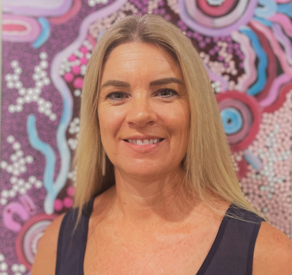 A portrait of Rebecca Famlonga in front of an indigenous art piece