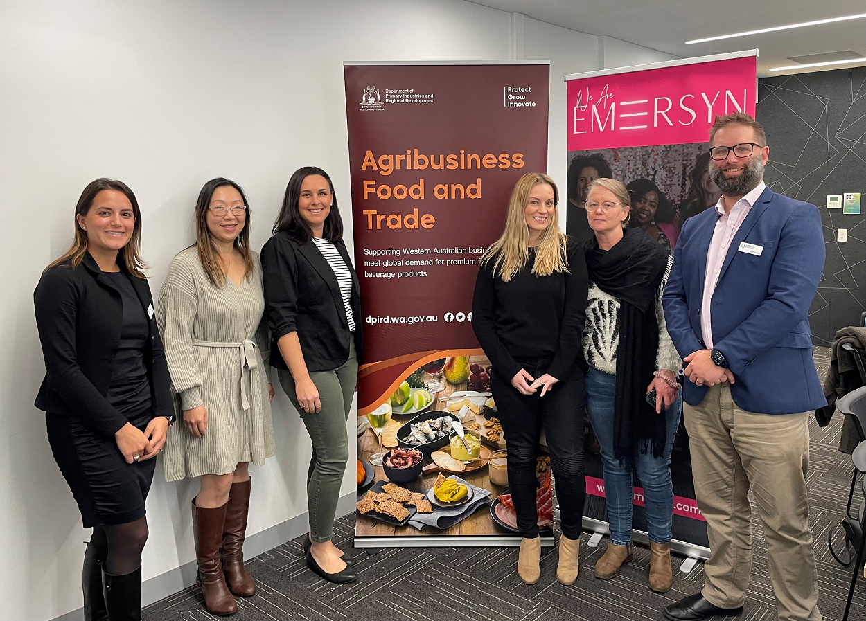 DPIRD and program participants standing in-front of Agribusiness Food and Trade banner. 