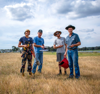 Four individuals standing in a field