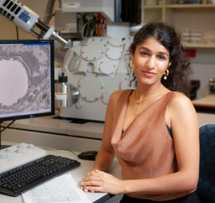 A portrait of Somayra Mamsa sitting at a desk in a laboratory