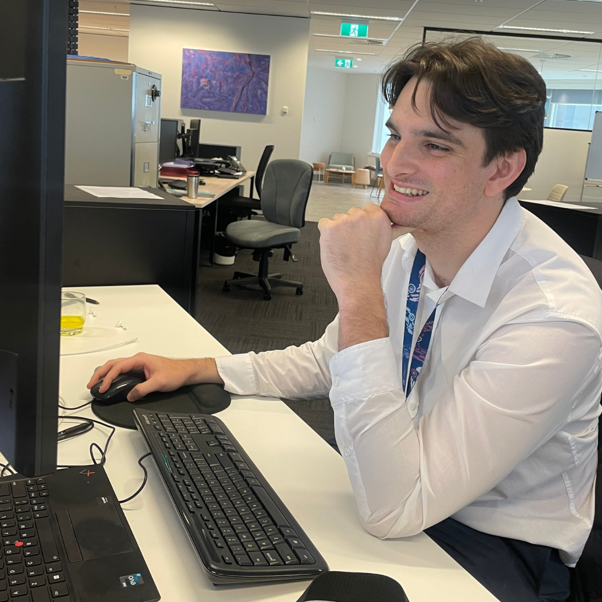 Graduate sitting at his desk using the computer