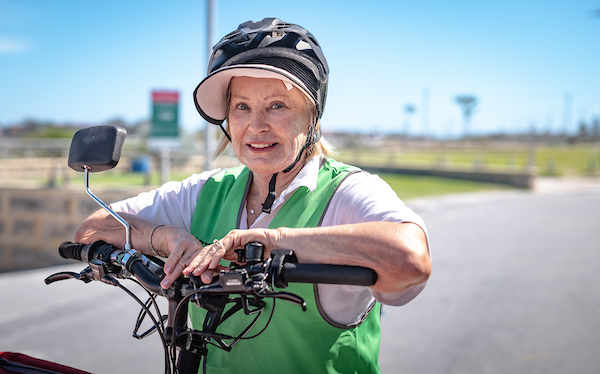 A photo of a woman aged in her seniors years on her bicycle