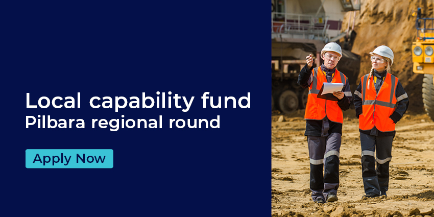 Two people wearing high visibility workwear looking out over an industrial area.