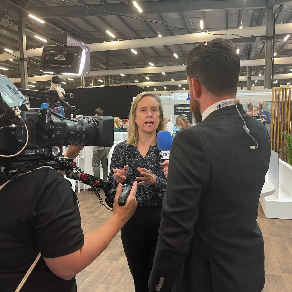 Minister *** is being interviewed by a camera crew at WA's booth at SPE offshore. 