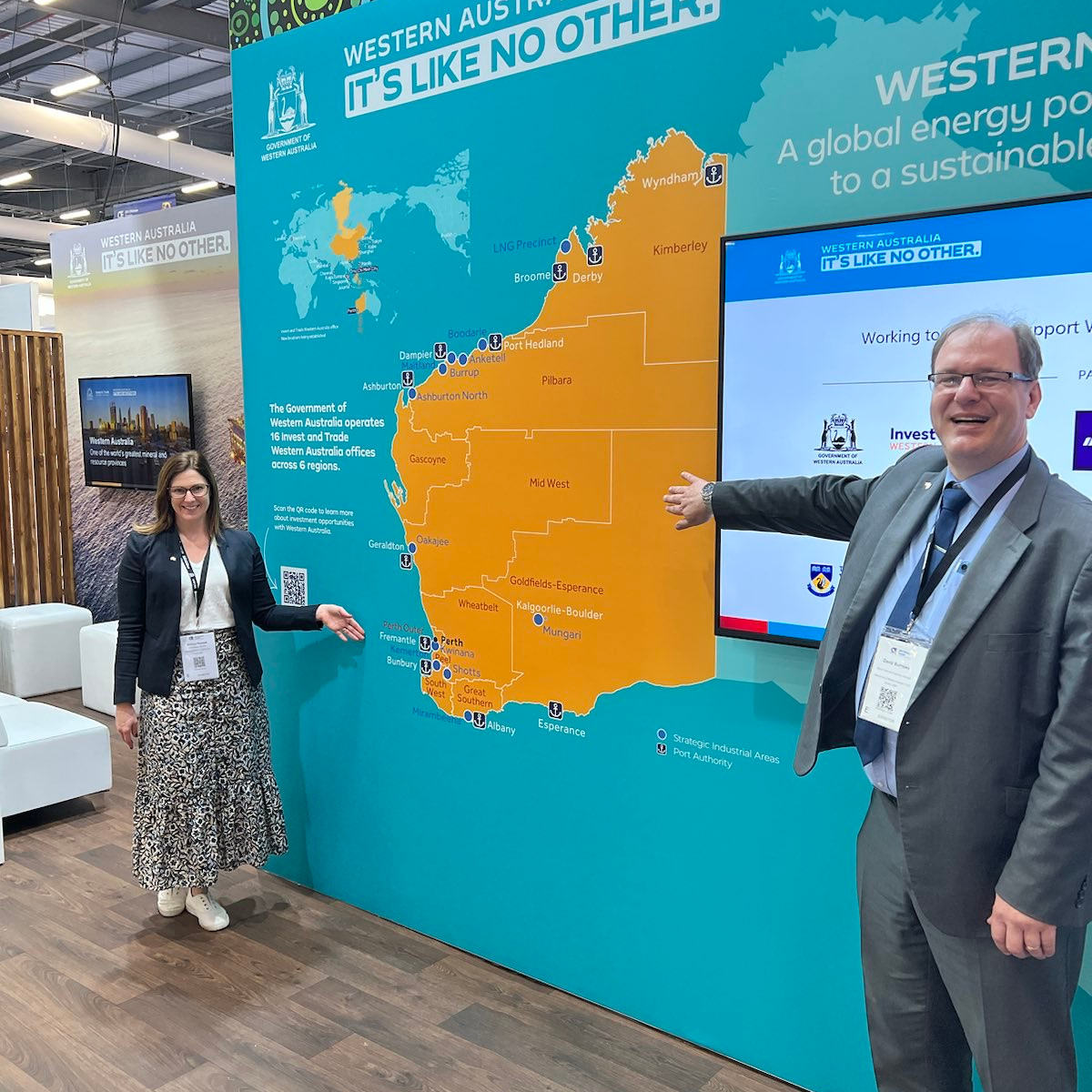 Representatives at WA's booth at SPE offshore in Scotland. The two people are standing on either side of a map of WA