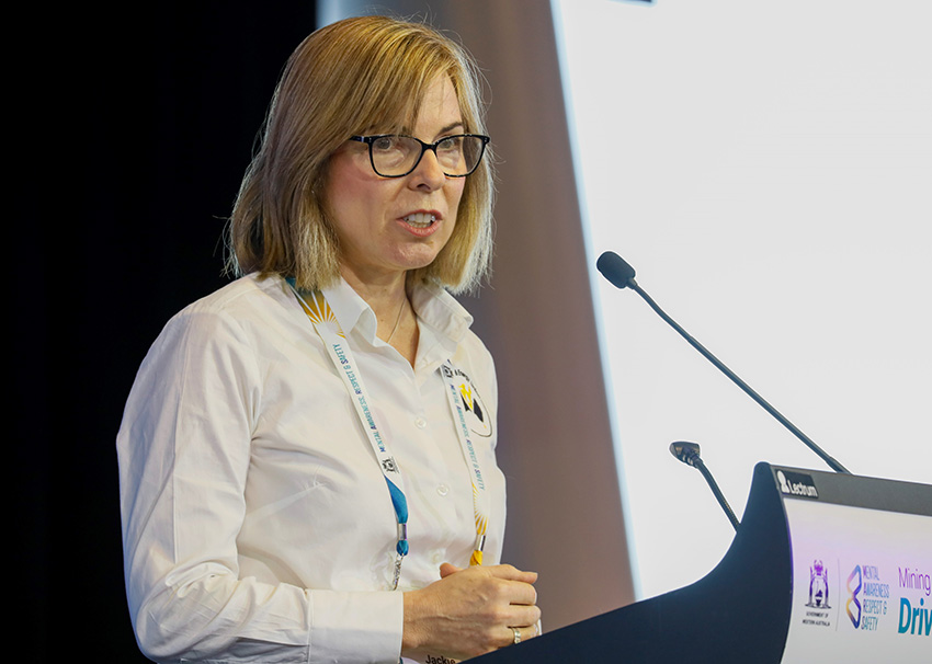 Woman in white shirt addressing the summit