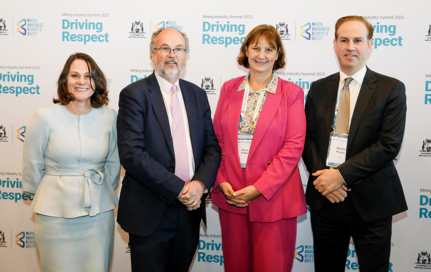 Four smiling well dressed people