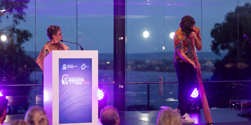 Image of Robyn Collard and a musician delivering the Welcome to Country at the WA Innovator of the Year 2023 awards ceremony