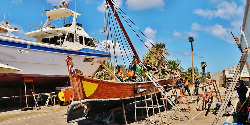 Prisoners from Greenough Regional Prison raise the Batavia longboat's mast during restoration work.