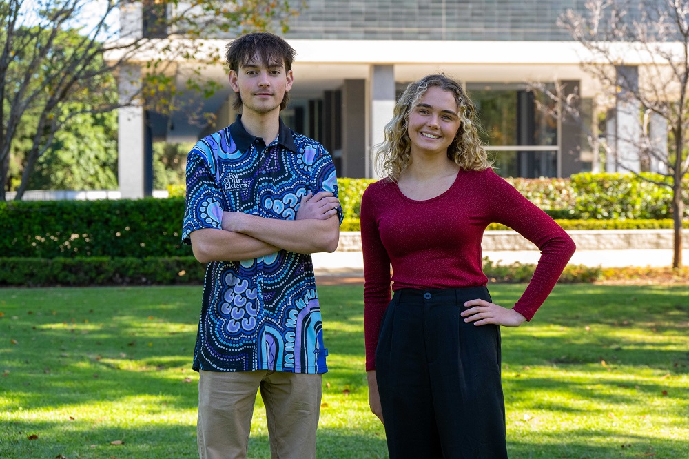 Bianca and Jett from the Public Sector Vacation Program standing outside Dumas House.