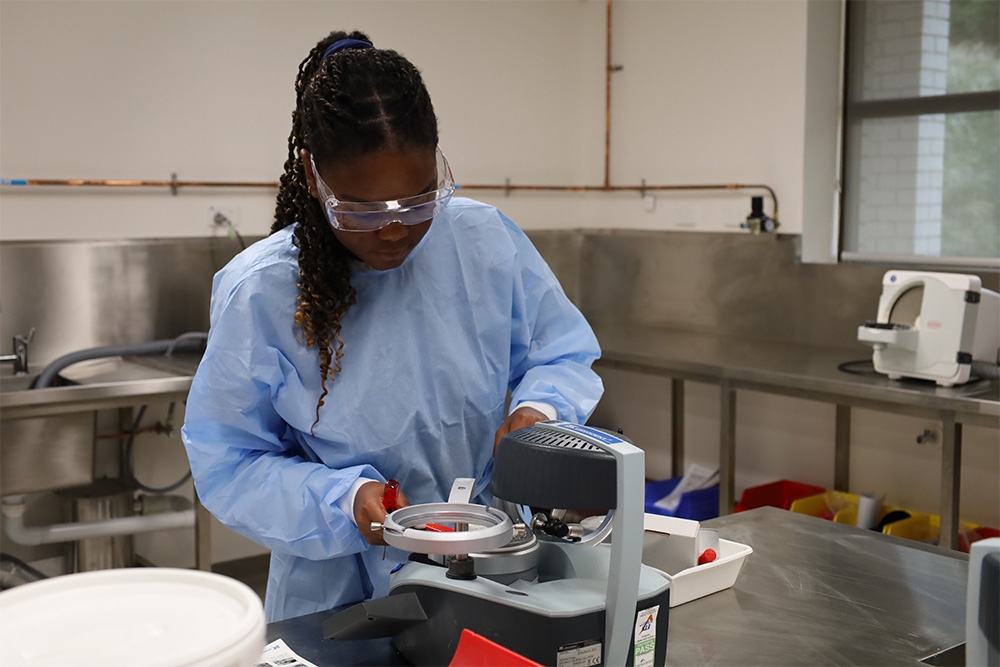 A TAFE dental student using dentistry equipment in a dental laboratory.