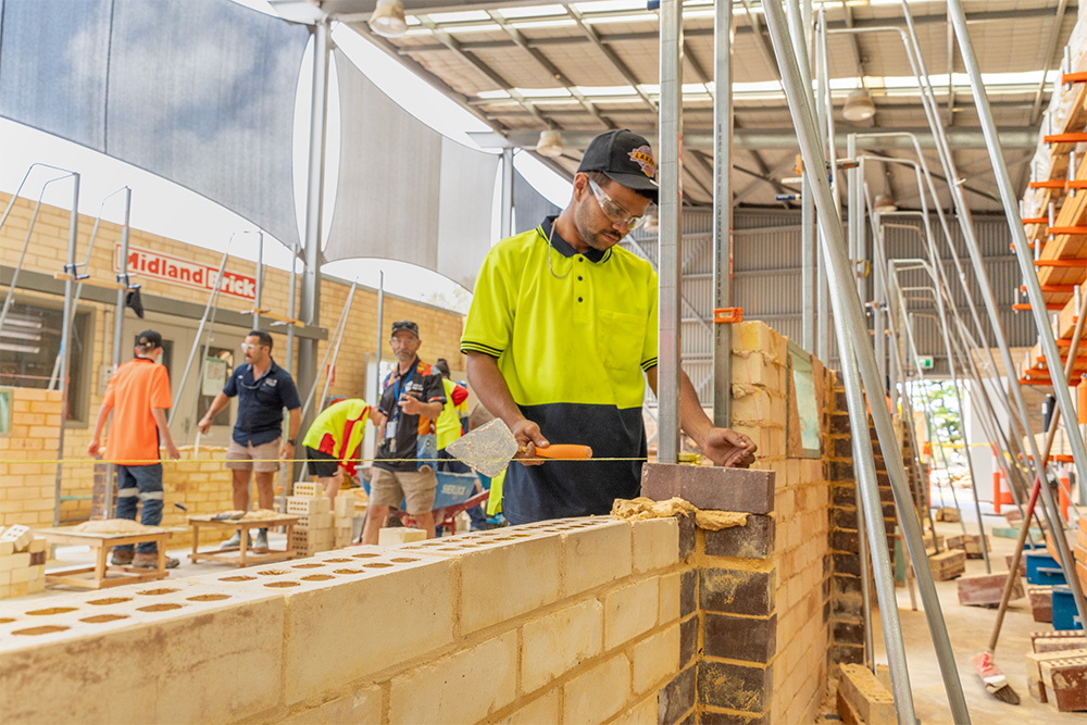 A bricklaying training session, where individuals are practicing their skills in a structured workshop environment.