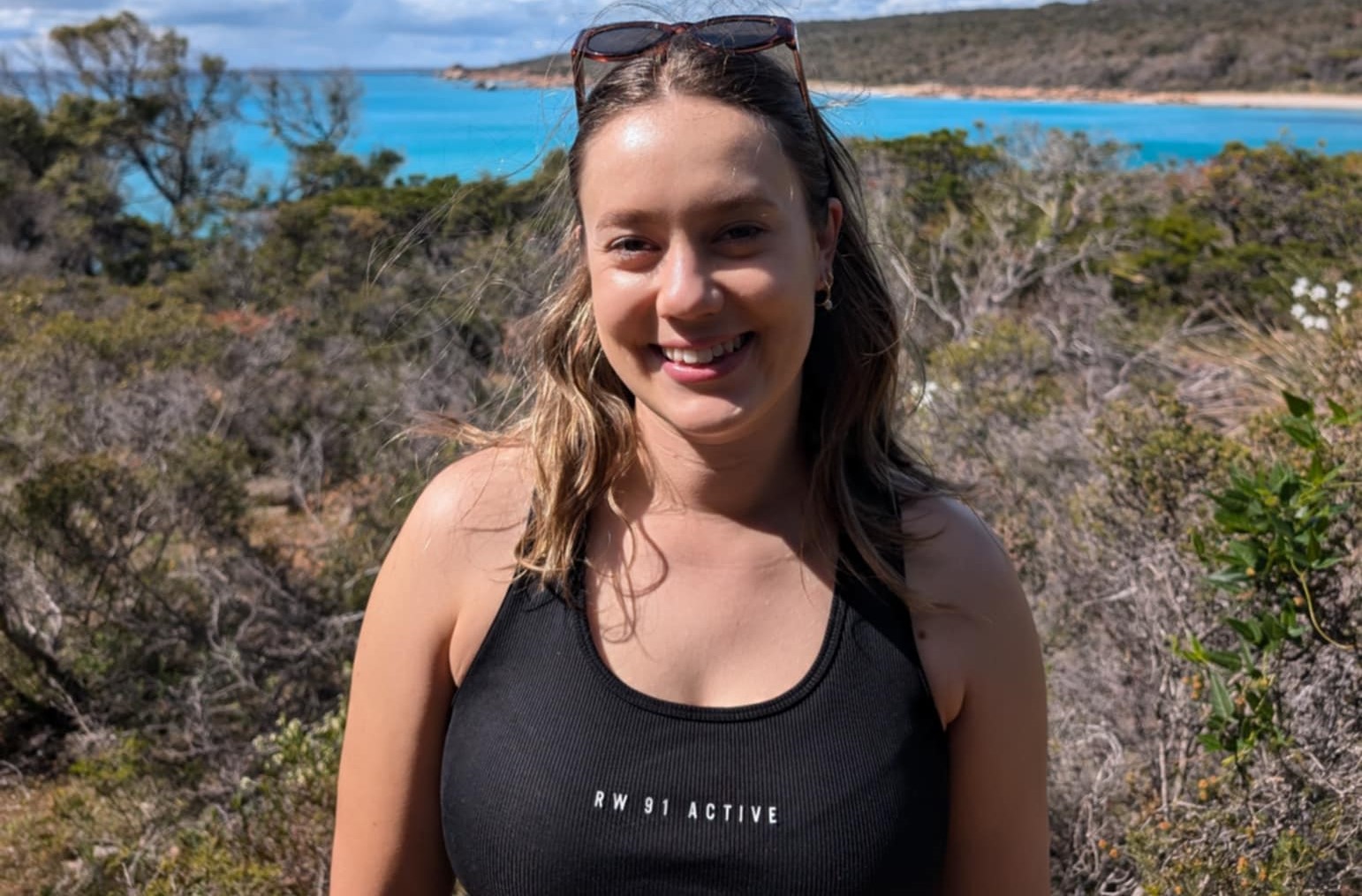 Image of a young woman in an outdoor setting smiling