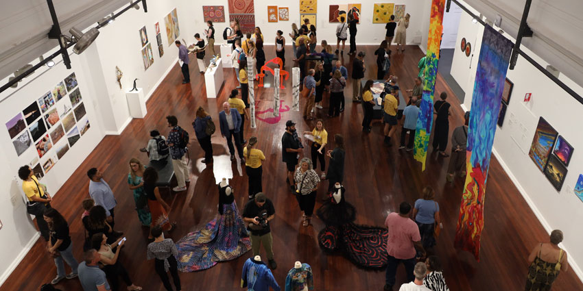 People visiting the art gallery and admiring the paintings on the wall