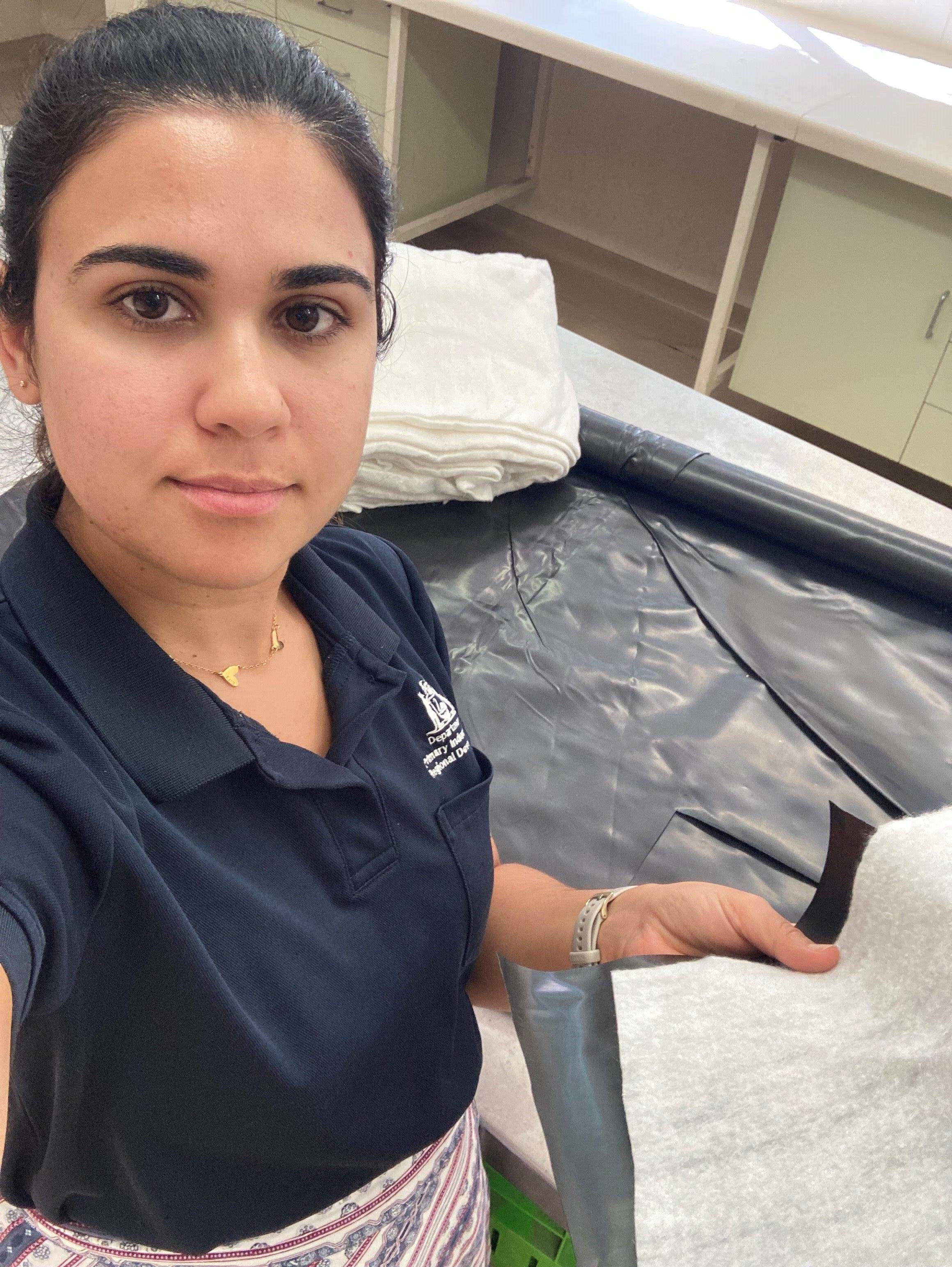 A woman holding black plastic.