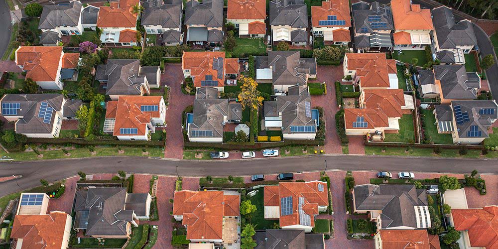 Aerial shot of rooftop solar panels on houses in a residential area