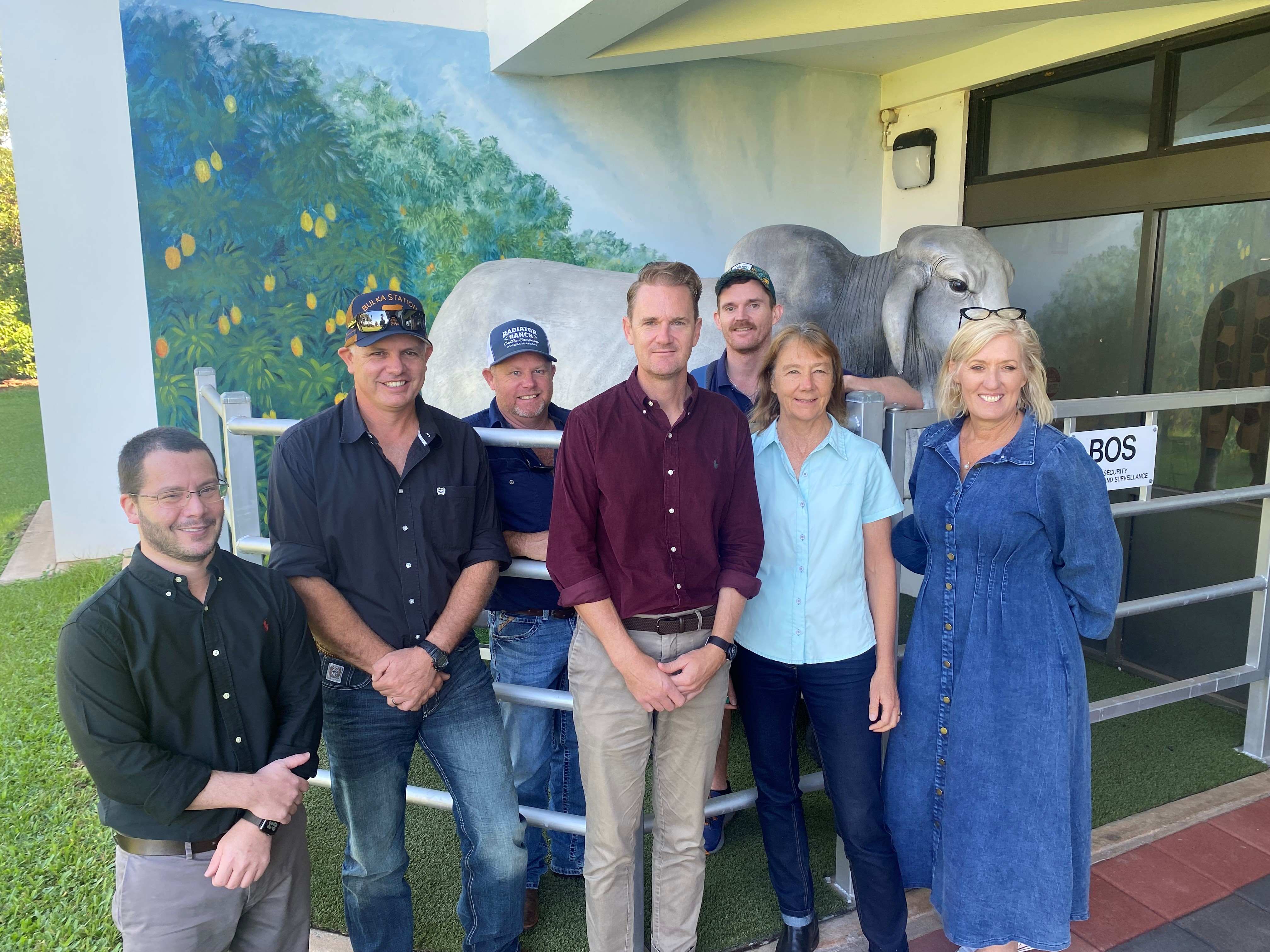 A group of men and women standing outside the doors of a modern building.