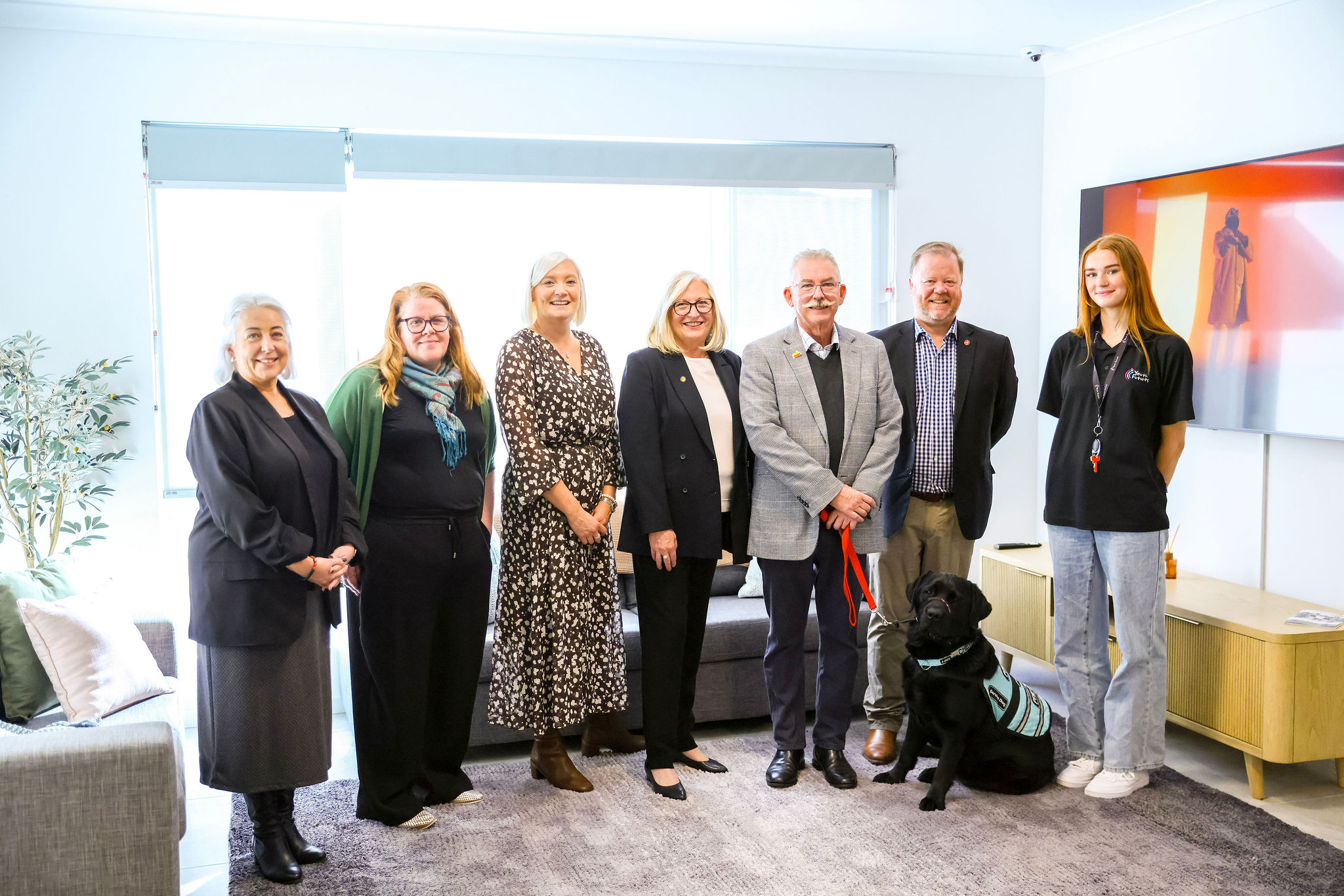 Group photo of a group of stakeholders inside the accommodation of a new youth homelessness accommodation