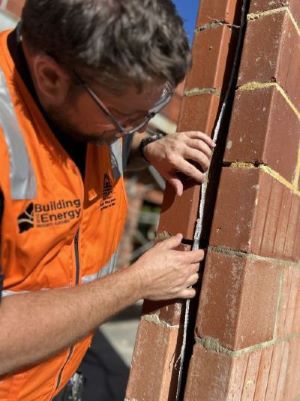 Audit team member looking at wall insulation