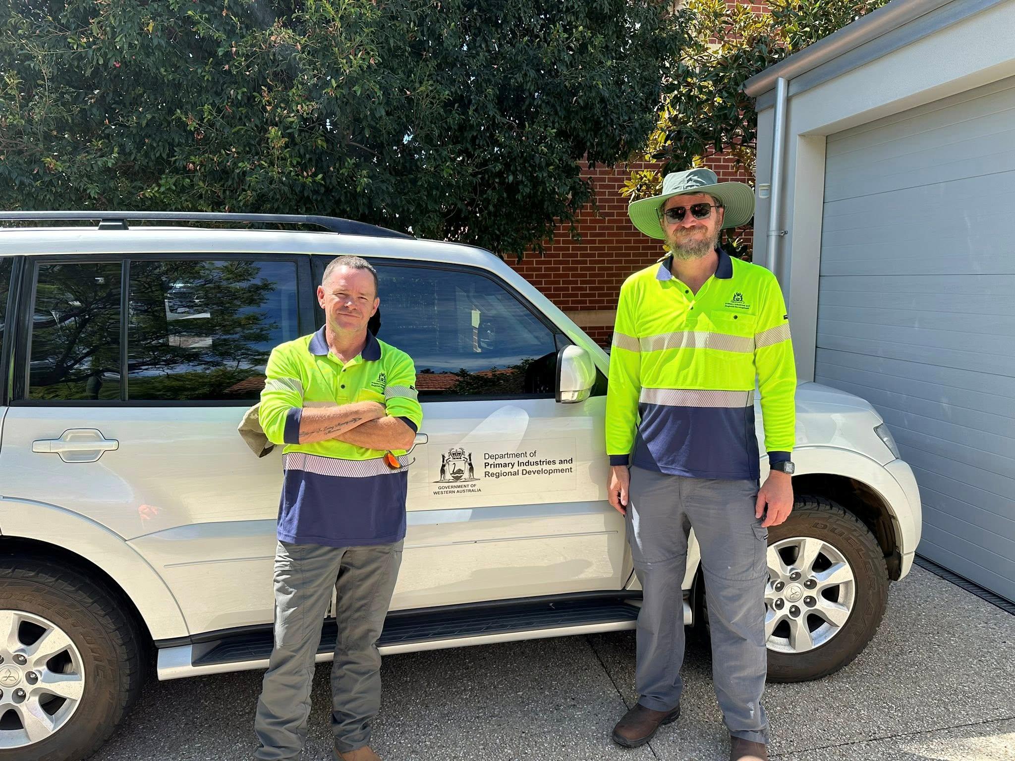 Two men standing near a four wheel drive.