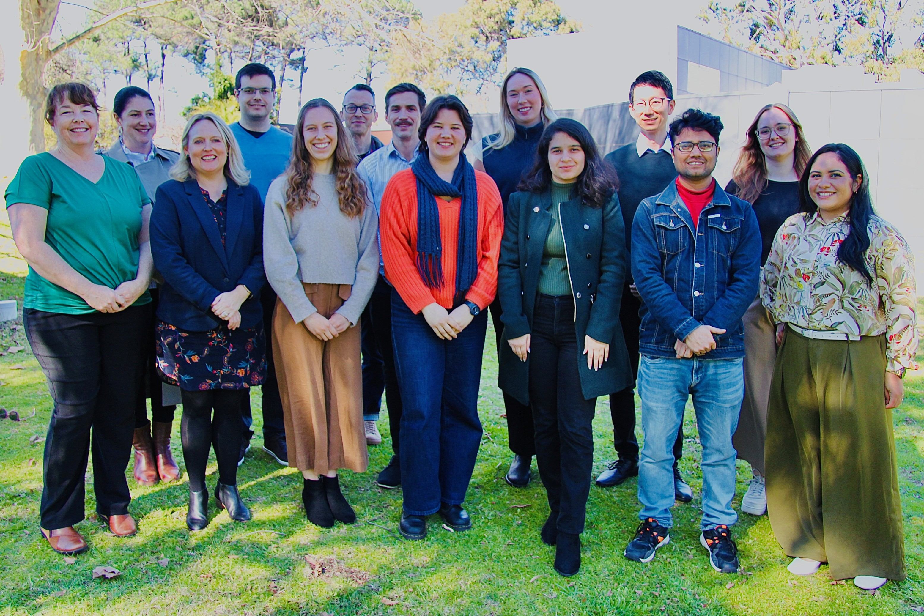 A large group of people standing under a tree.