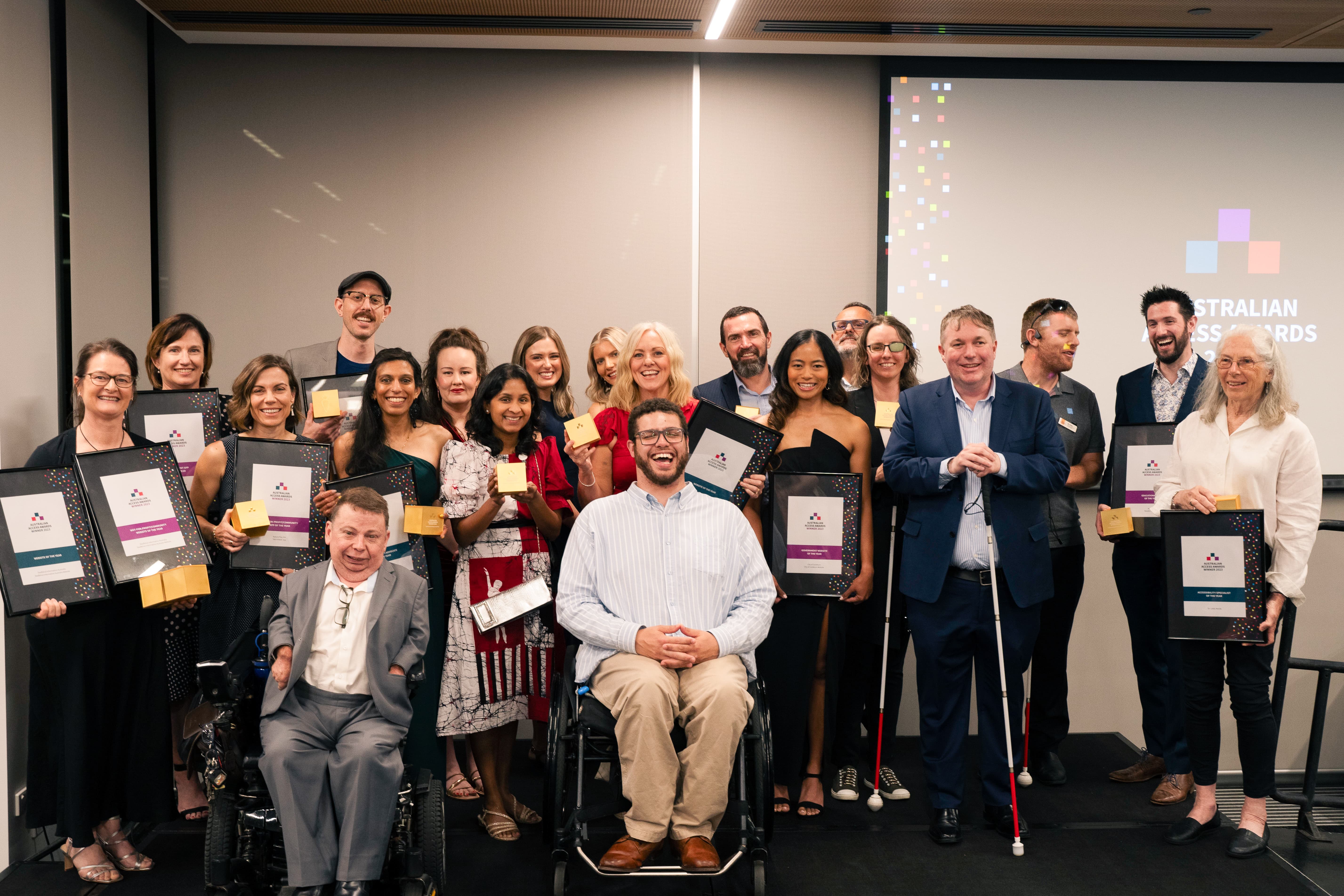 a group of differently abled people celebrating and holding awards