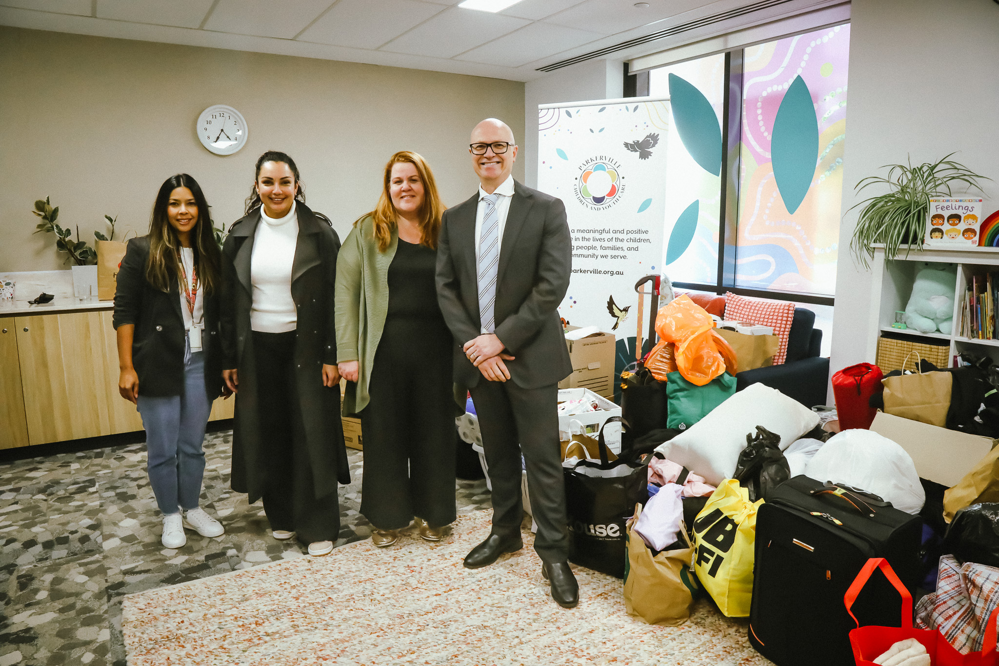 Image of Department of Communities staff together with gifts being donated