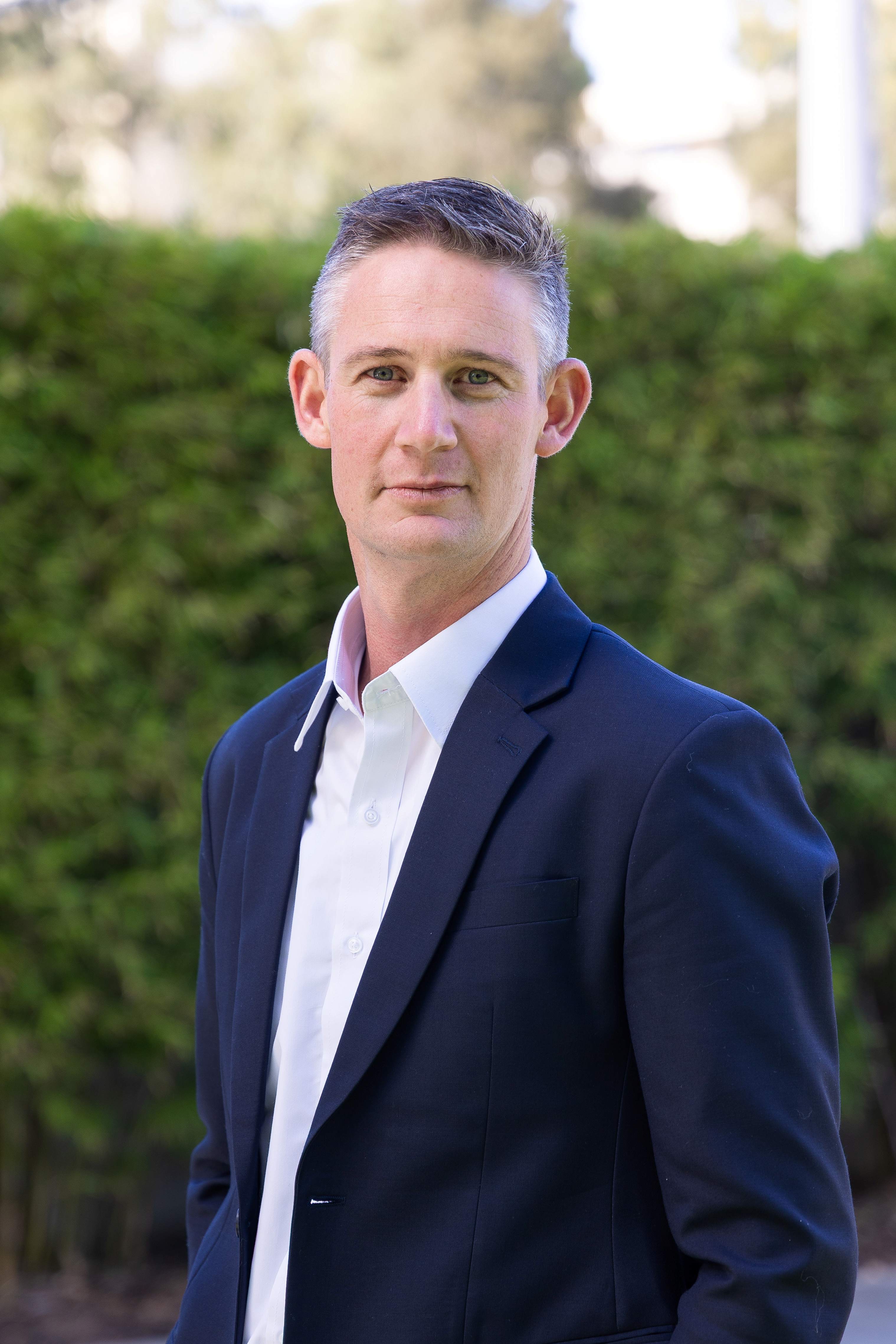 A headshot of a man in a suit.