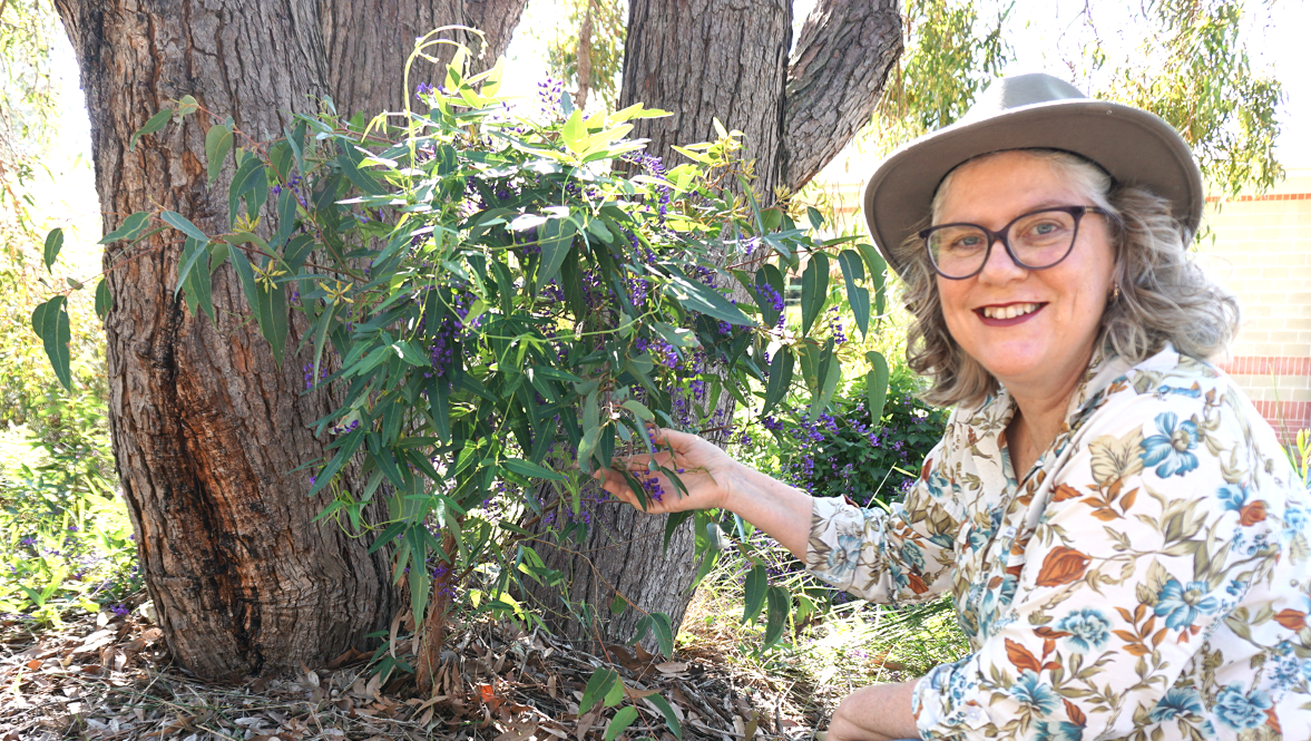 psa finalistjanene sproul kneeling to hold berries hanging from a bush tree