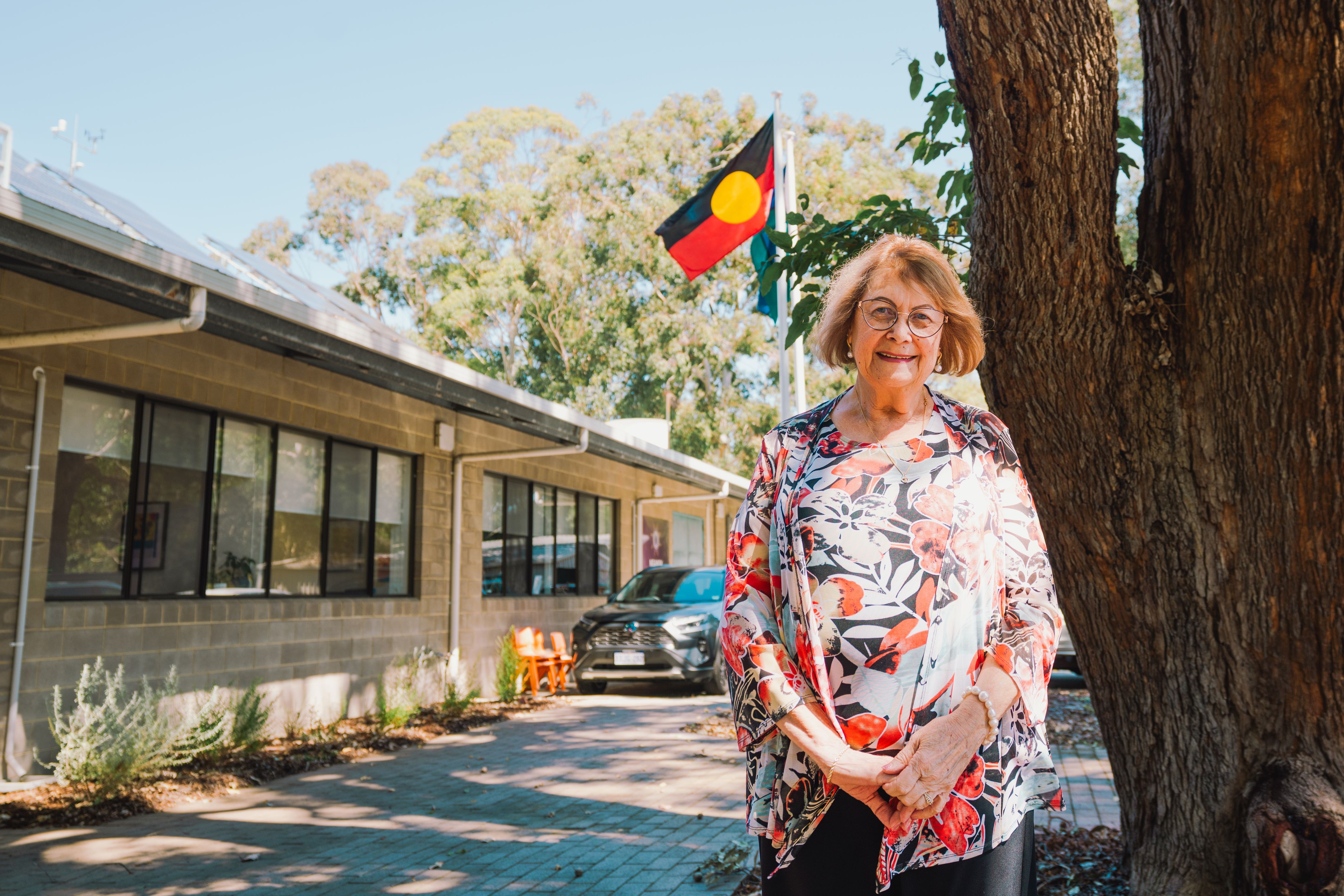 psa finalist rhonda marriot standing in front of office with Aboriginal flag in the background