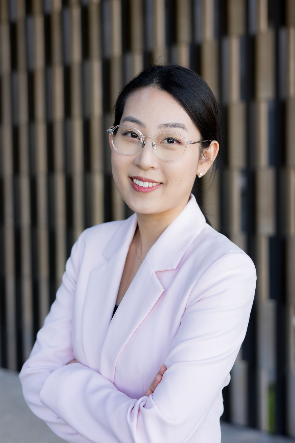 Close shot of psa finalist tammy lee in a light pick blazer standing with arms crossed