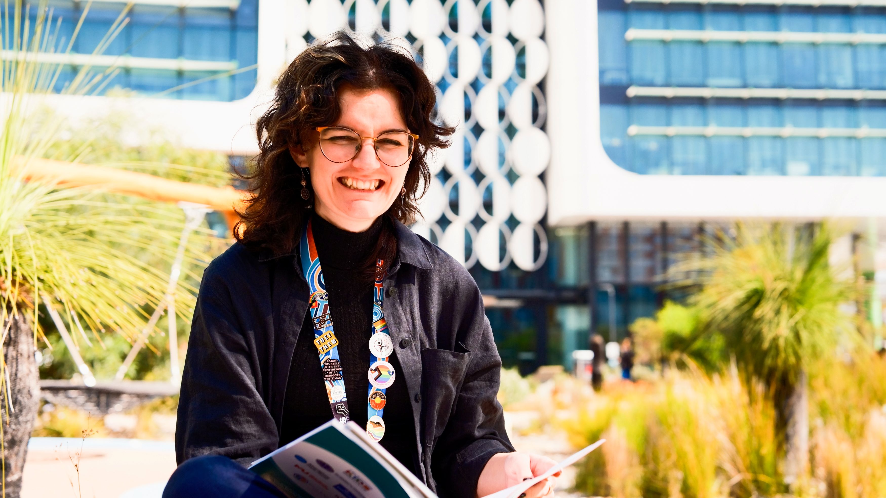psa finalist shakara liddelow sitting in a park with a report book on their hand