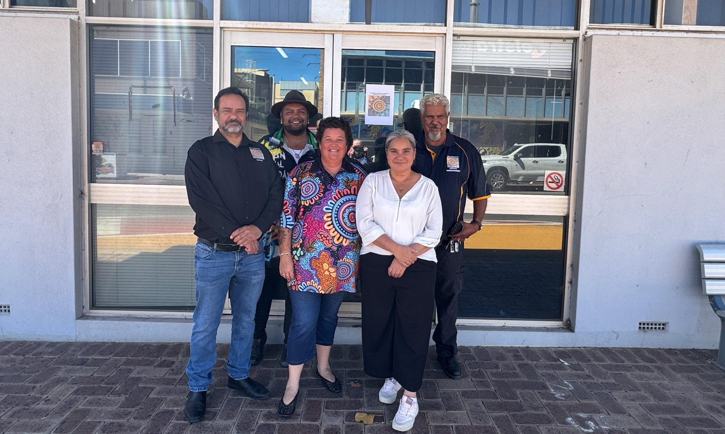 a group of staff, including Aboriginal men and women, in an outdoor setting