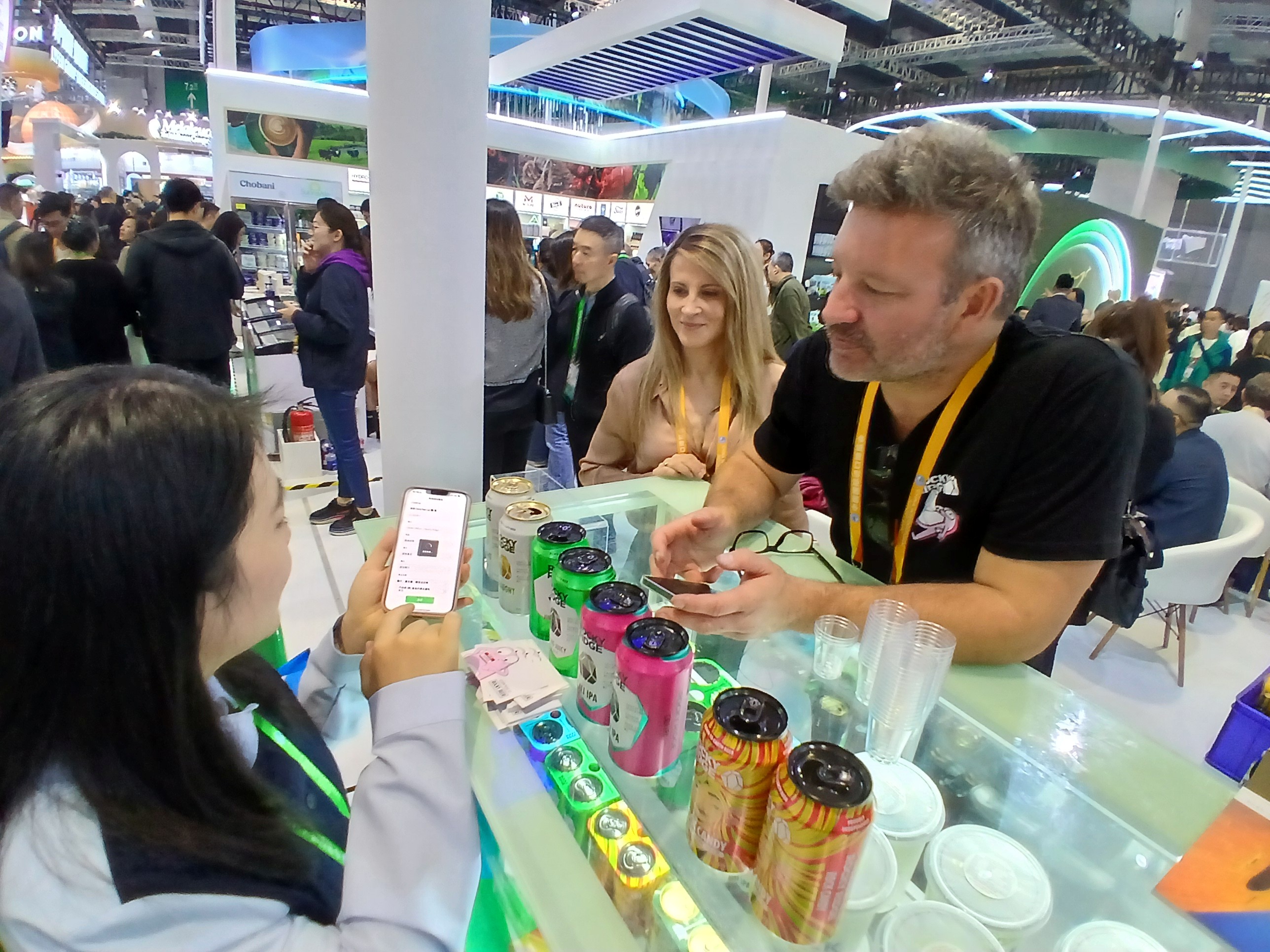 A man talking to two women in a trade display.