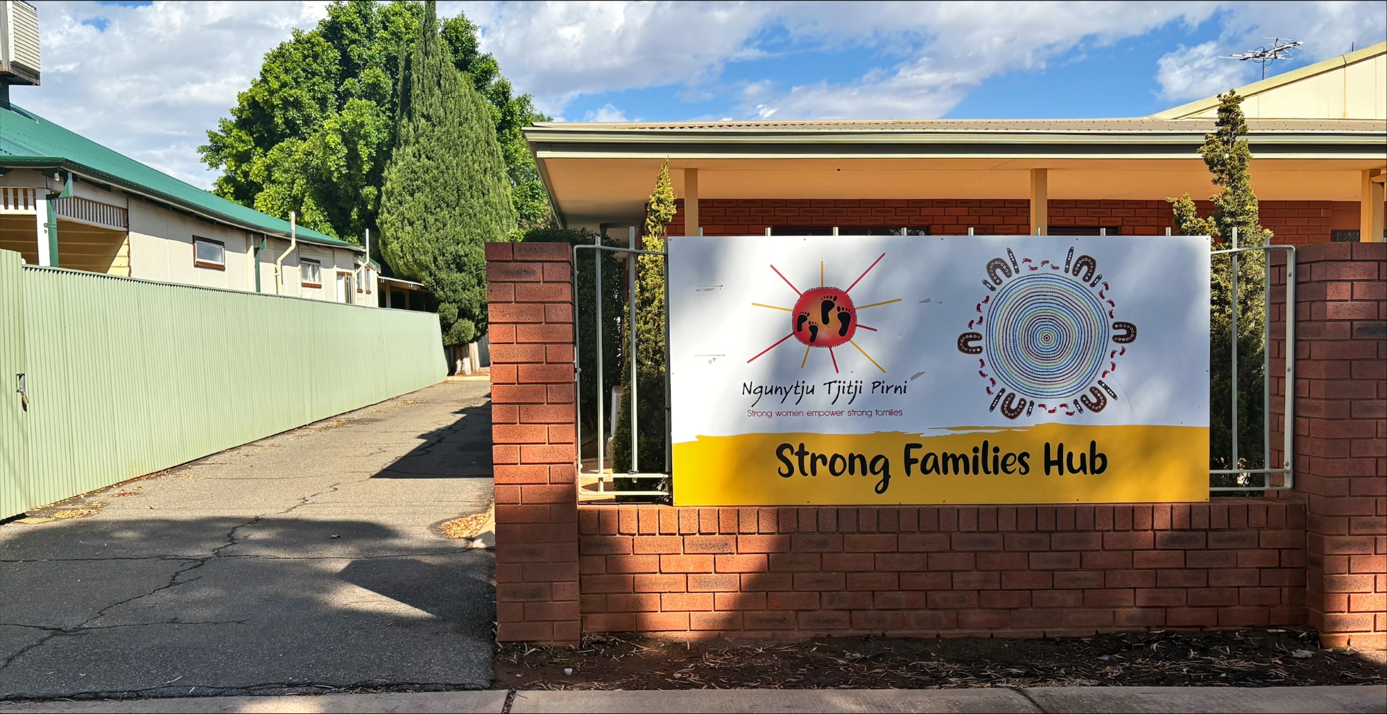 A red brick building with a sign on the front of the building that reads Strong Family Hub