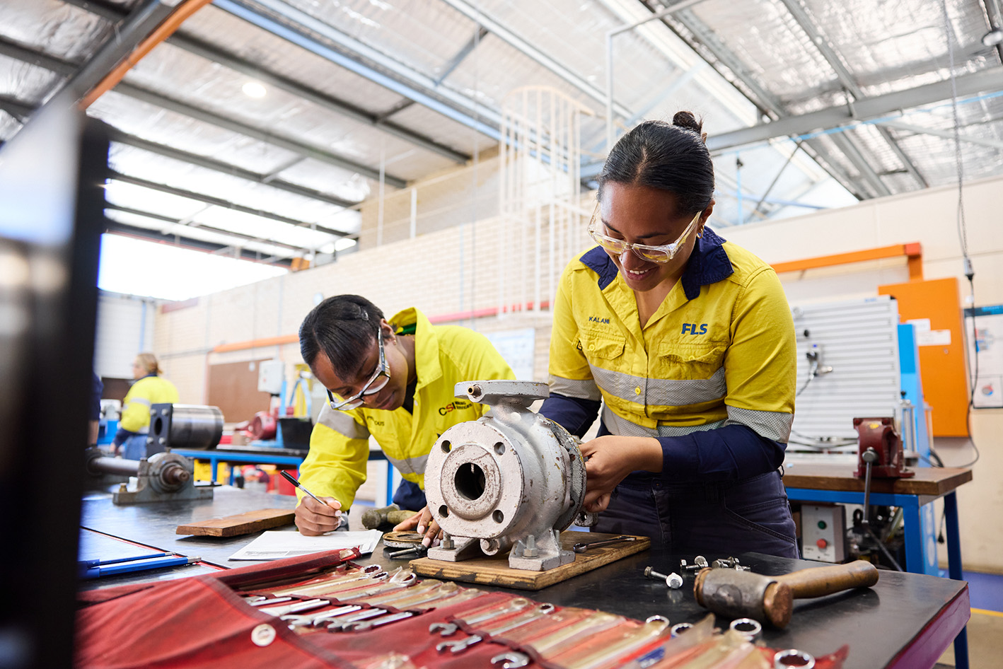 two women working in trades with tools